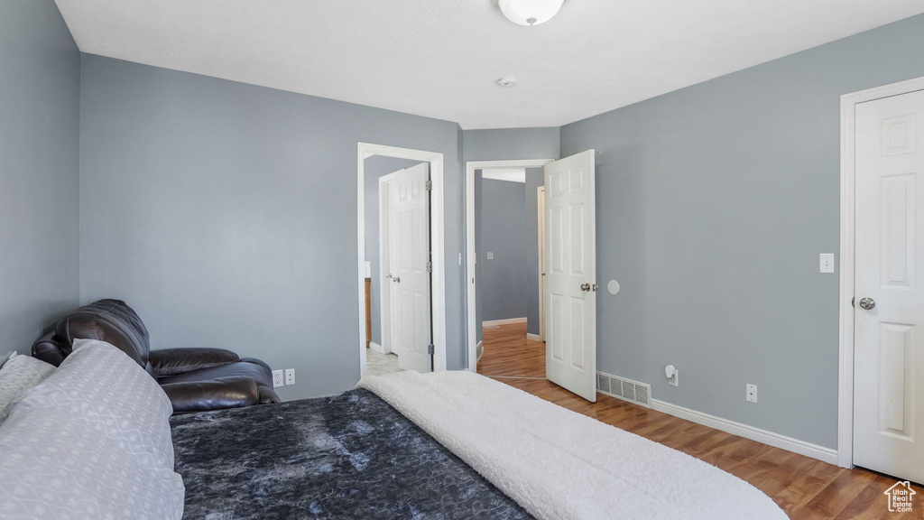 Bedroom with wood finished floors and baseboards