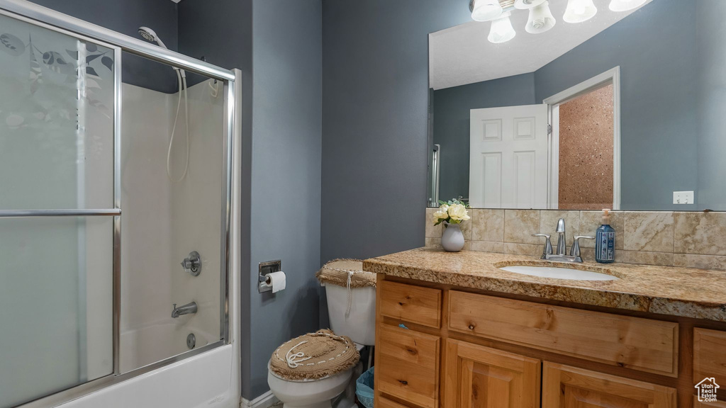 Bathroom featuring vanity and shower / bath combination with glass door