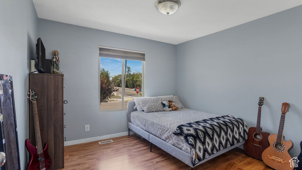 Bedroom featuring wood finished floors and baseboards
