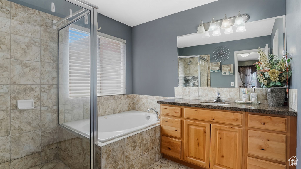 Bathroom with vanity, a bath, a stall shower, and tile patterned flooring