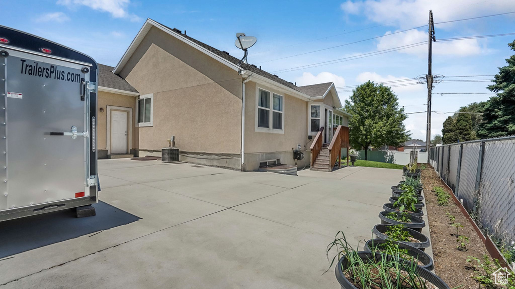 Back of house featuring stucco siding, a fenced backyard, and a patio area