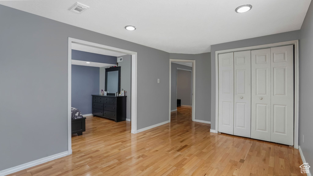 Unfurnished bedroom featuring light wood finished floors and a closet