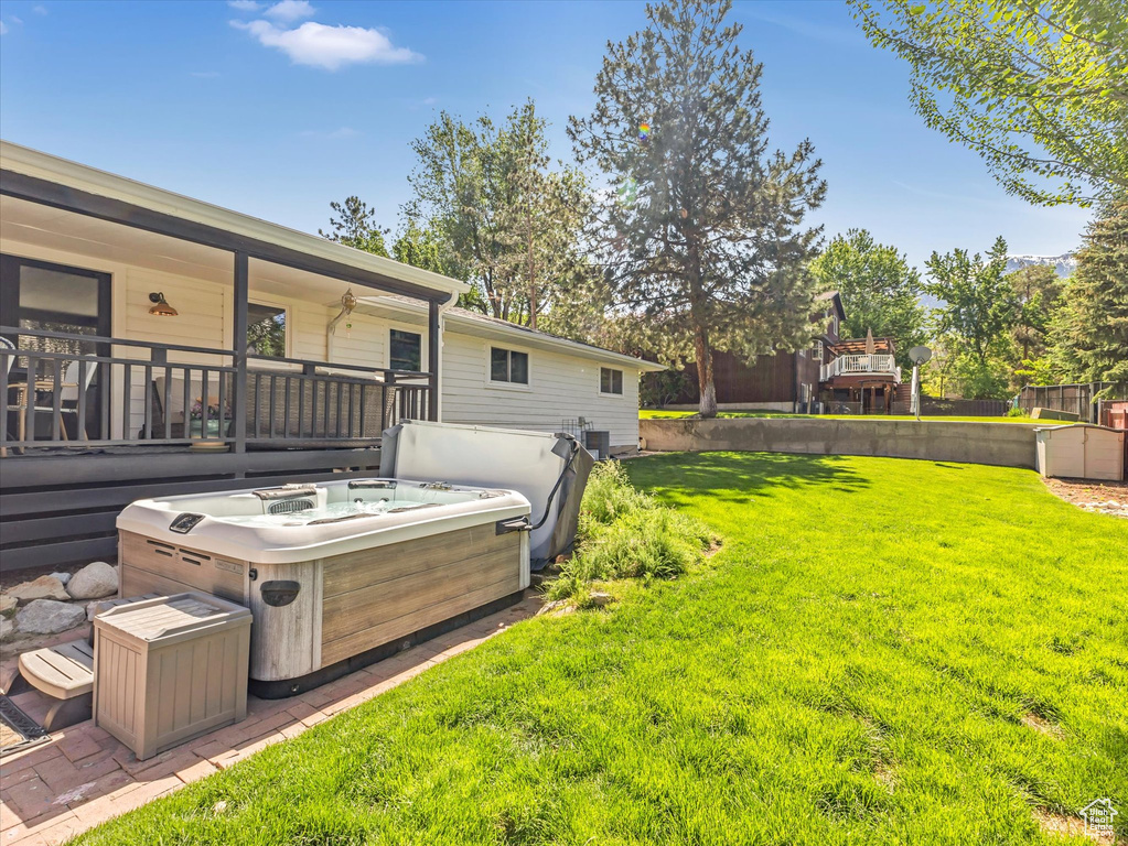 View of grassy yard featuring a hot tub