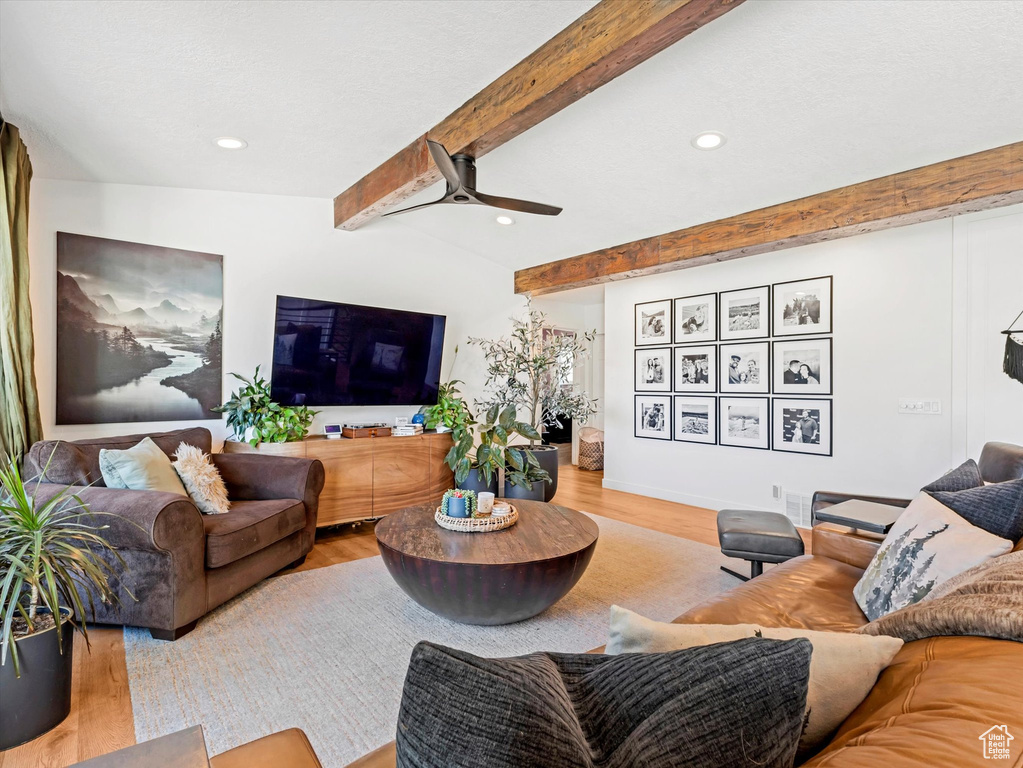 Living room with wood finished floors, beam ceiling, ceiling fan, and recessed lighting