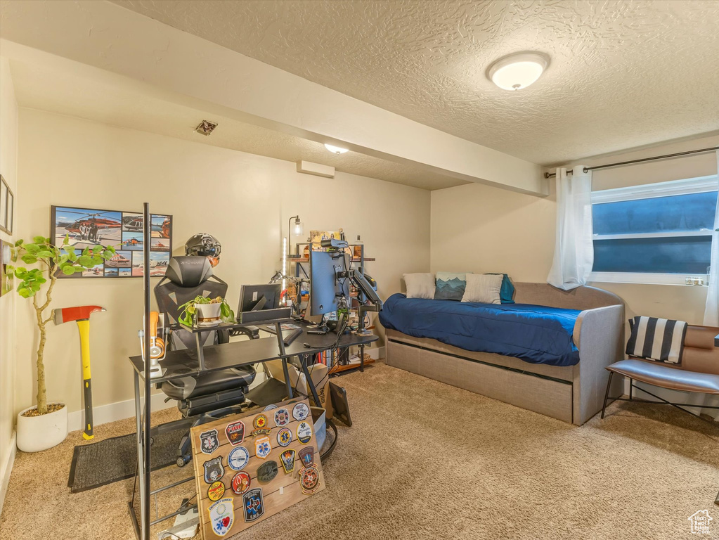 Carpeted bedroom with a textured ceiling and baseboards