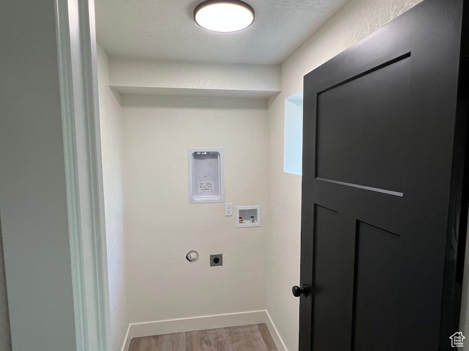 Washroom featuring wood finished floors, hookup for an electric dryer, and hookup for a washing machine