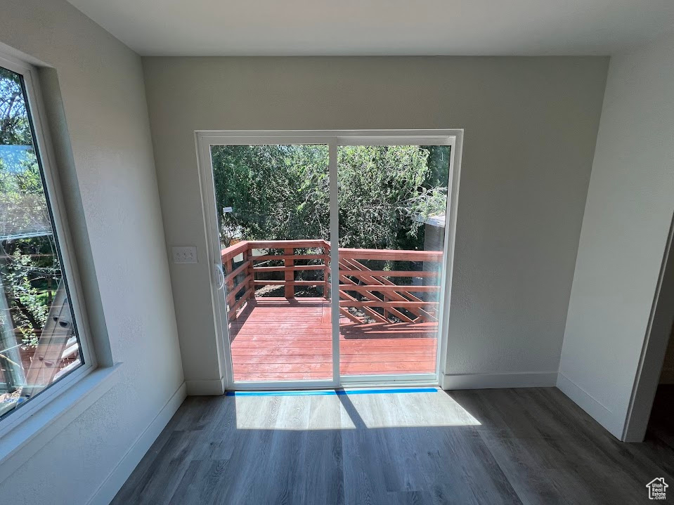 Doorway to outside with plenty of natural light and wood finished floors