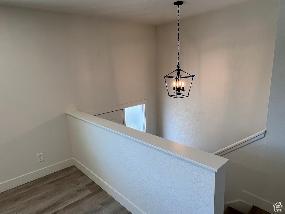 Detailed view of wood finished floors and a chandelier