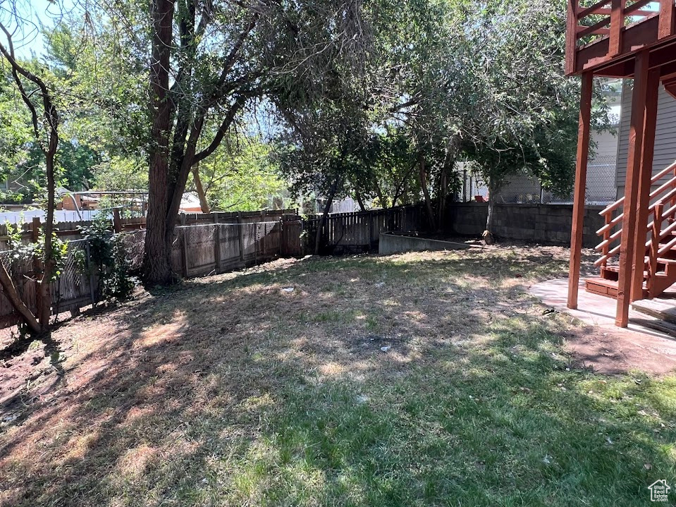 Fenced backyard featuring stairway