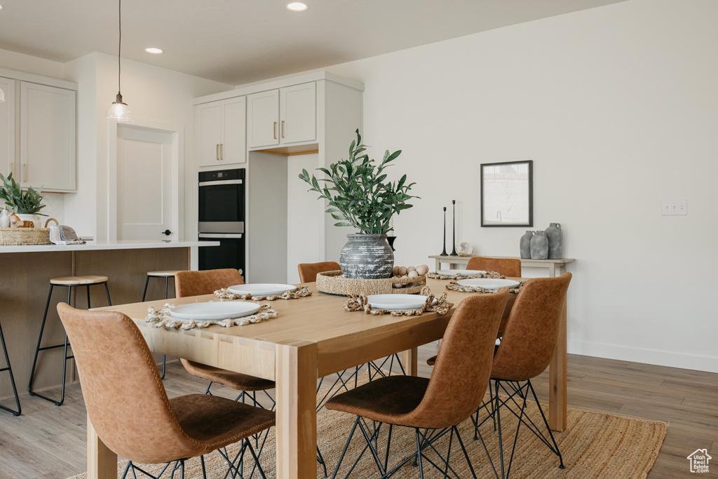 Dining area with light wood-style flooring and recessed lighting