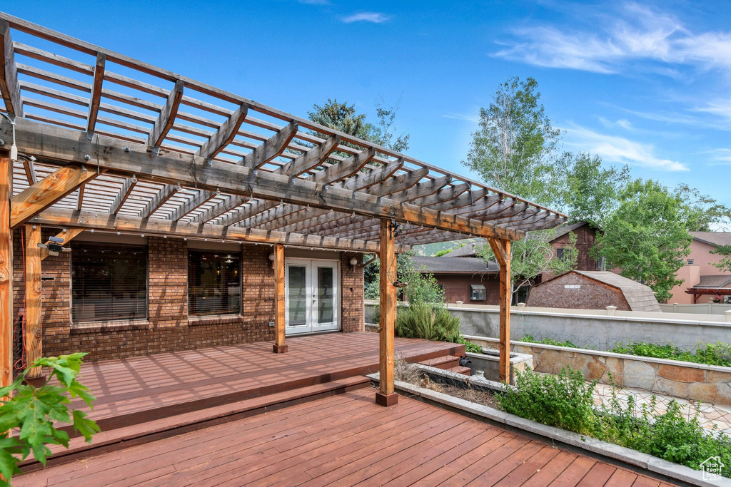 Wooden terrace featuring french doors and a pergola