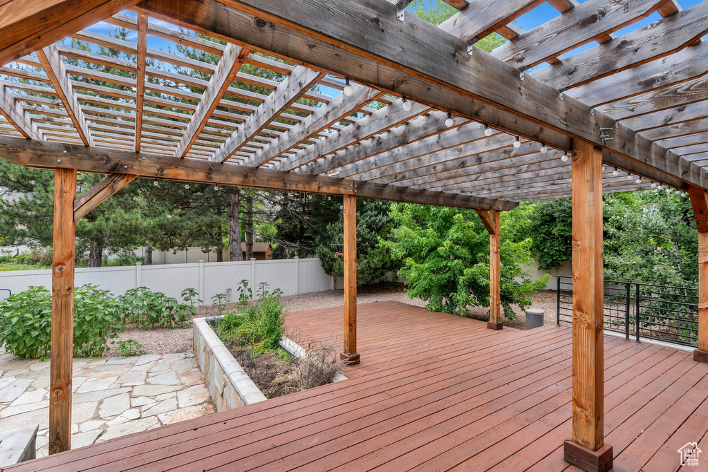 Wooden terrace featuring a fenced backyard and a pergola