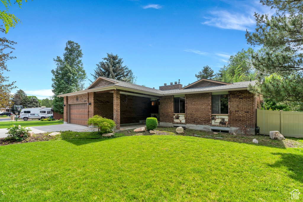 Single story home with brick siding, a garage, and concrete driveway