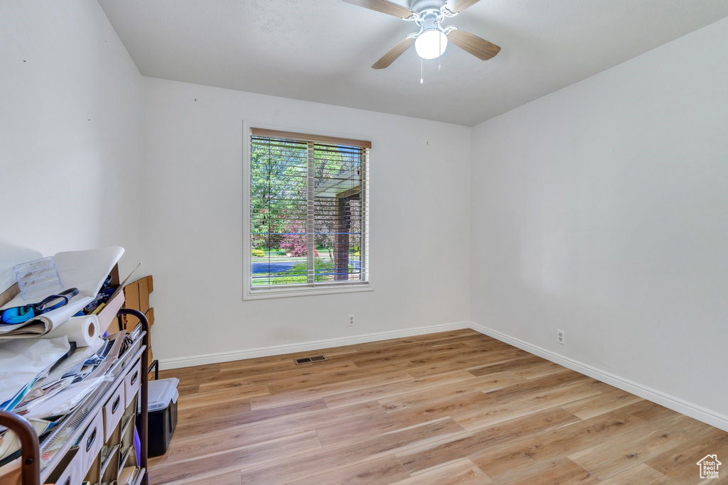 Empty room with light wood-style floors and ceiling fan