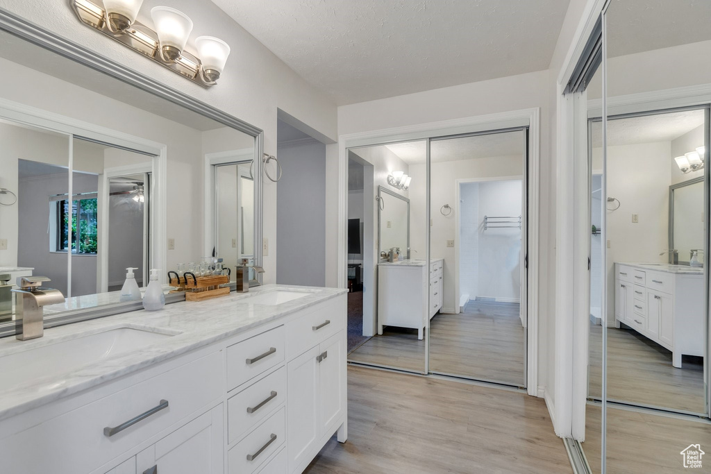 Bathroom featuring double vanity and wood finished floors