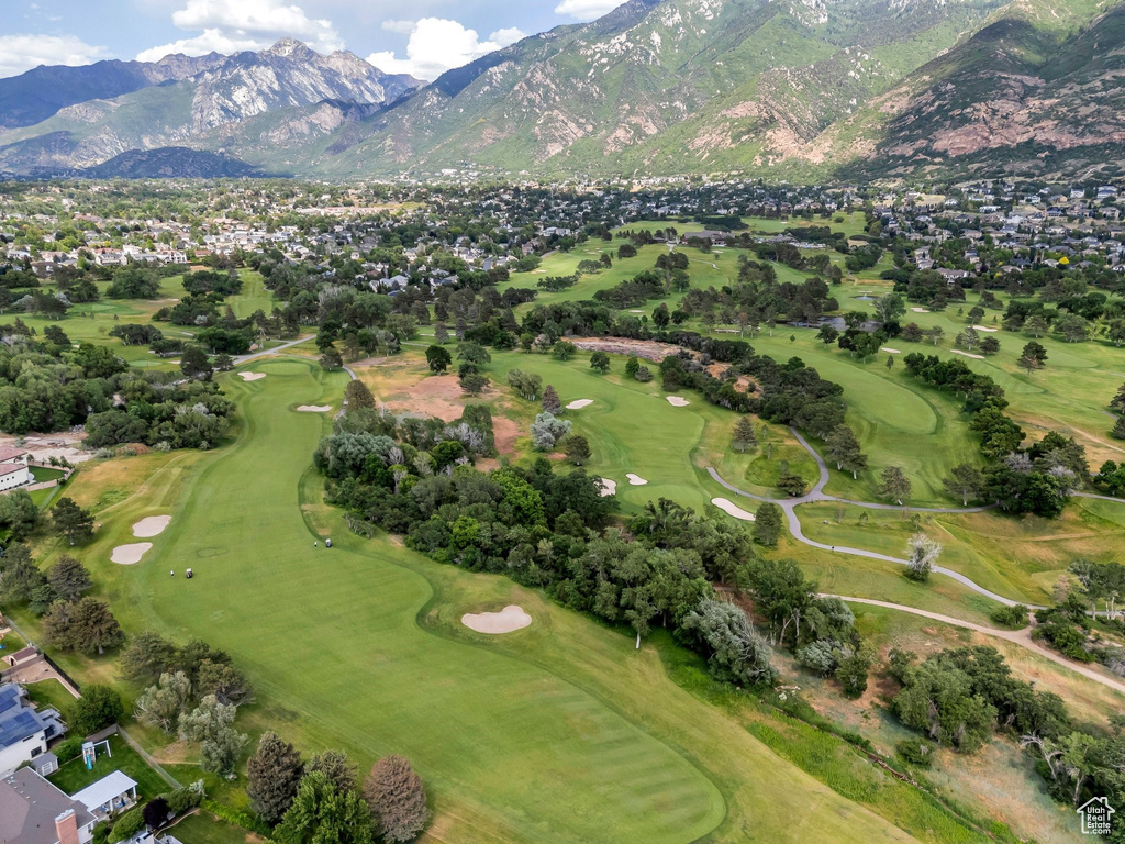 Aerial view of property and surrounding area with a golf club and a mountain backdrop