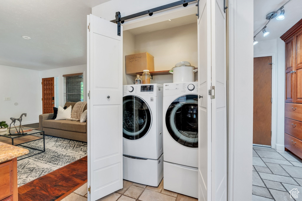 Laundry room featuring washer and clothes dryer and a barn door