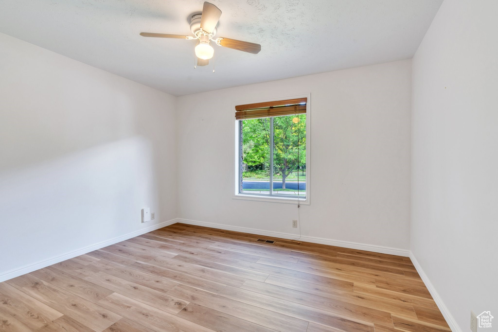 Spare room with a ceiling fan and light wood-style floors