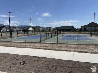 View of tennis court with a residential view