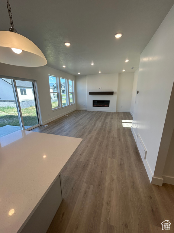 Unfurnished living room featuring wood finished floors, recessed lighting, and a fireplace