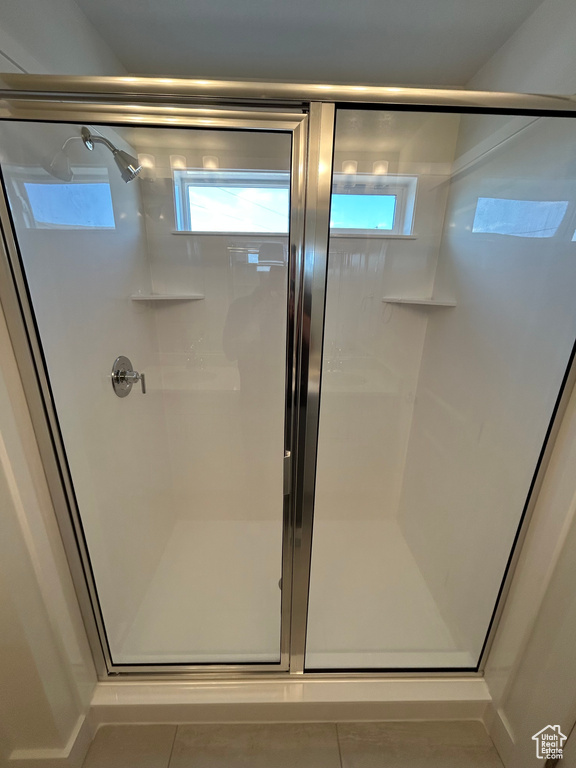 Bathroom with a shower stall and tile patterned floors