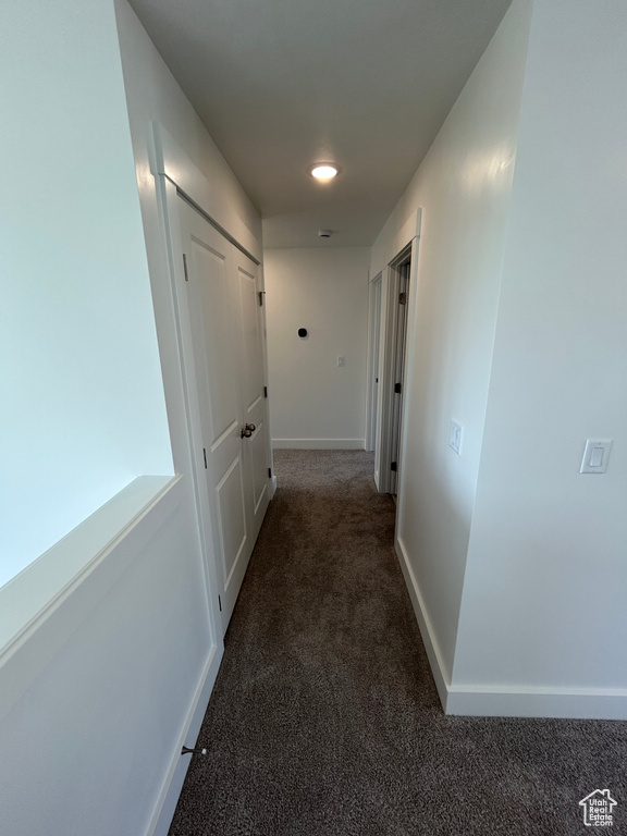 Corridor featuring carpet flooring and baseboards