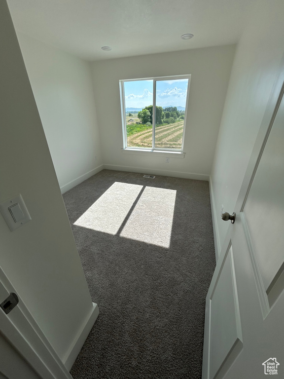 Carpeted spare room with baseboards
