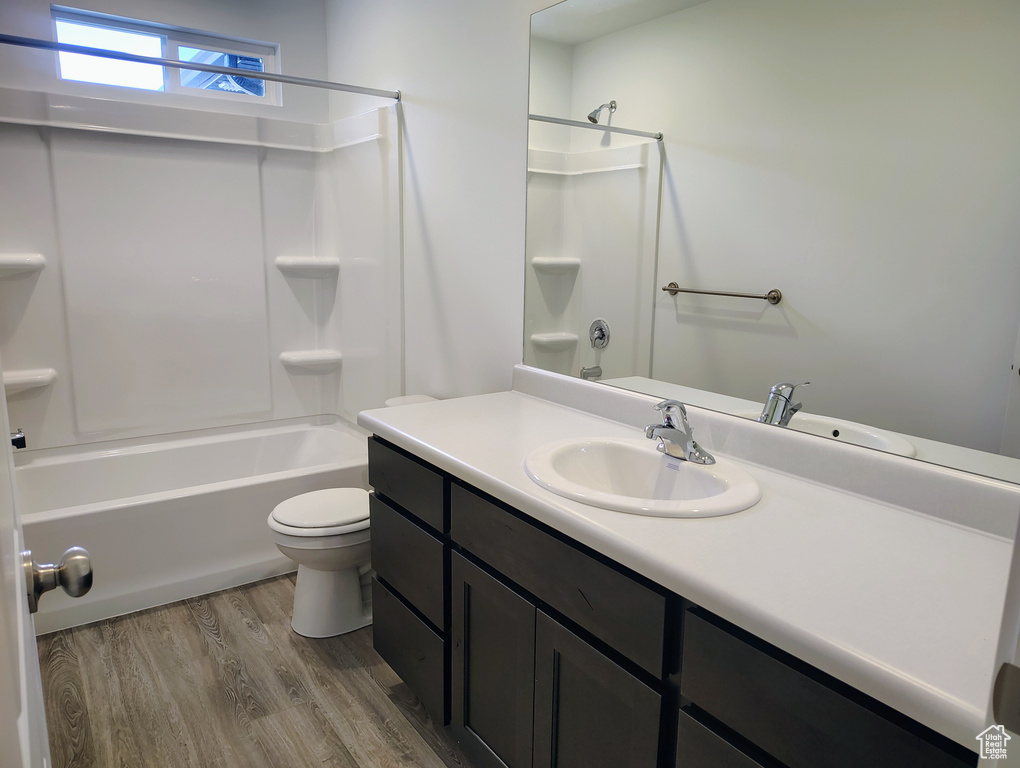 Full bathroom featuring vanity, wood finished floors, and washtub / shower combination
