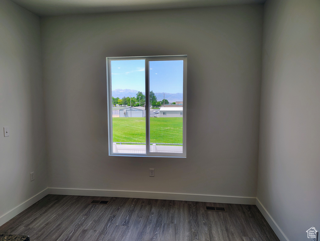 Unfurnished room featuring healthy amount of natural light and dark wood finished floors