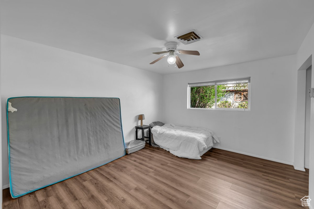Unfurnished bedroom with wood finished floors and a ceiling fan