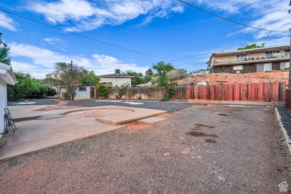 Fenced backyard with a storage shed and a patio