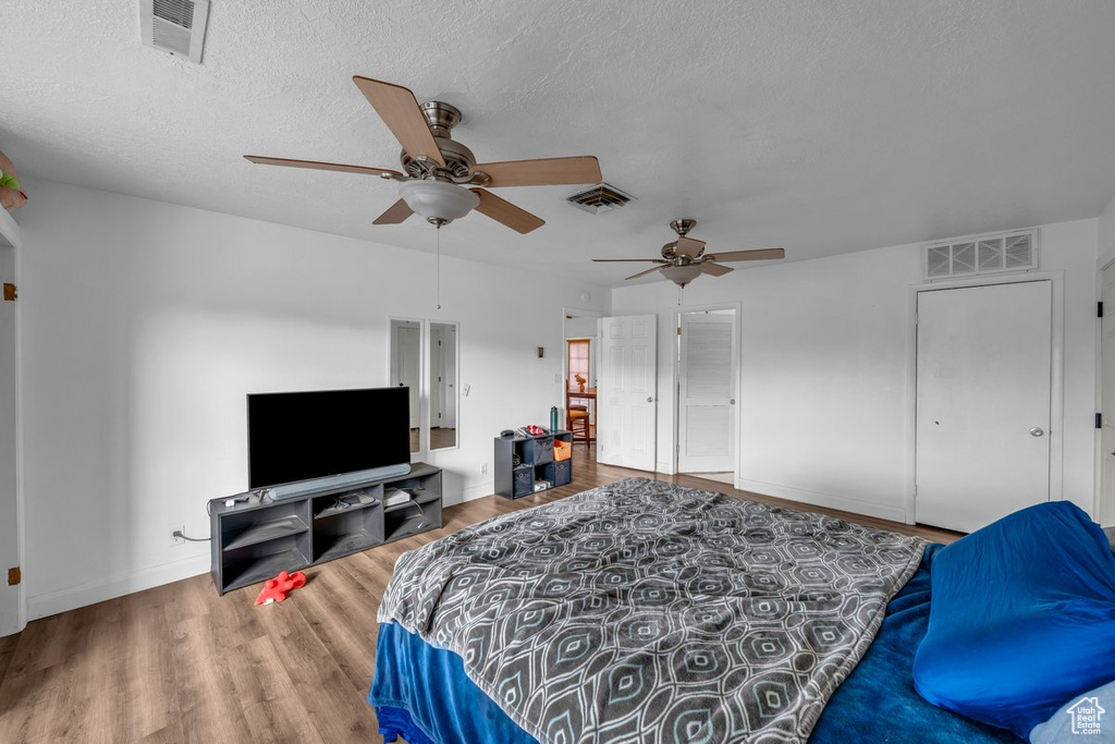 Bedroom featuring wood finished floors, a ceiling fan, and a textured ceiling