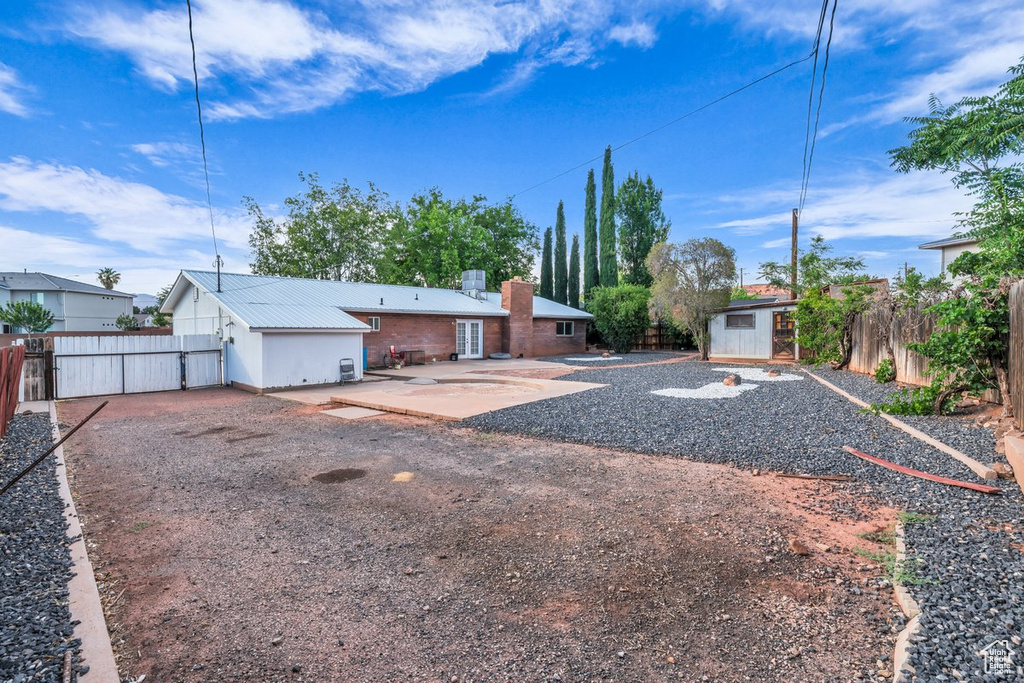 Back of property featuring a patio area, a fenced backyard, a shed, and a chimney