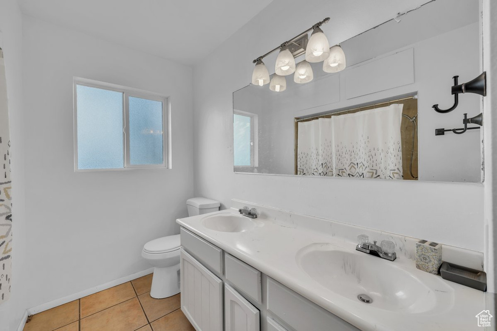 Bathroom with tile patterned flooring, double vanity, and a shower with curtain