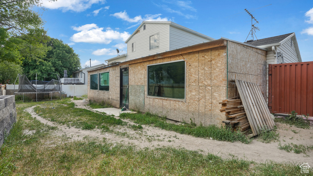 Back of house featuring a trampoline