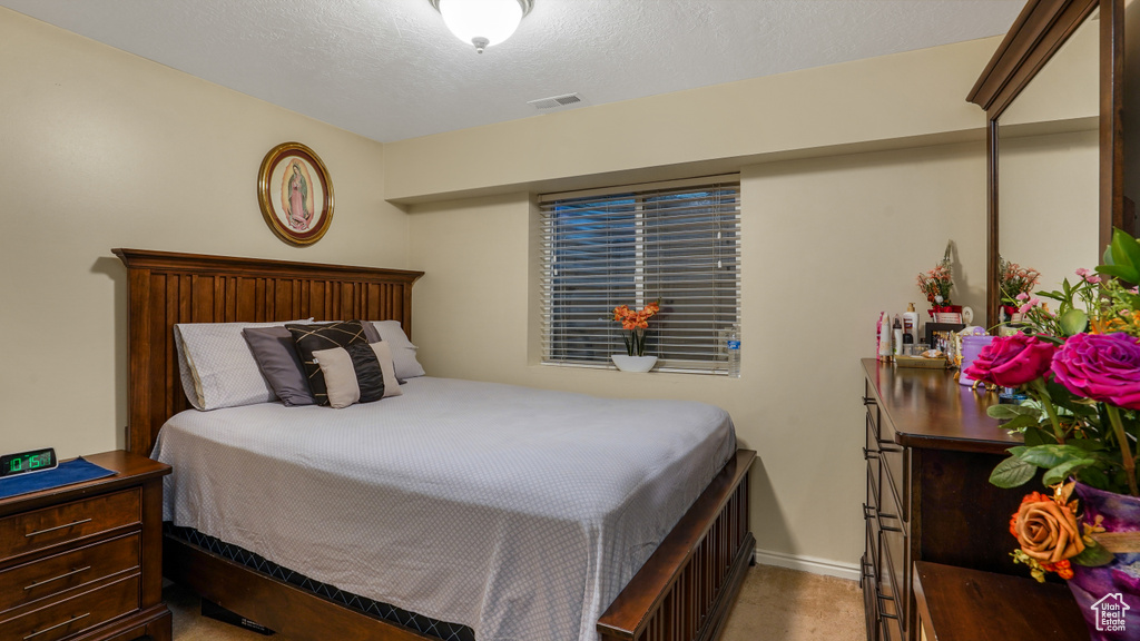 Bedroom featuring baseboards and a textured ceiling
