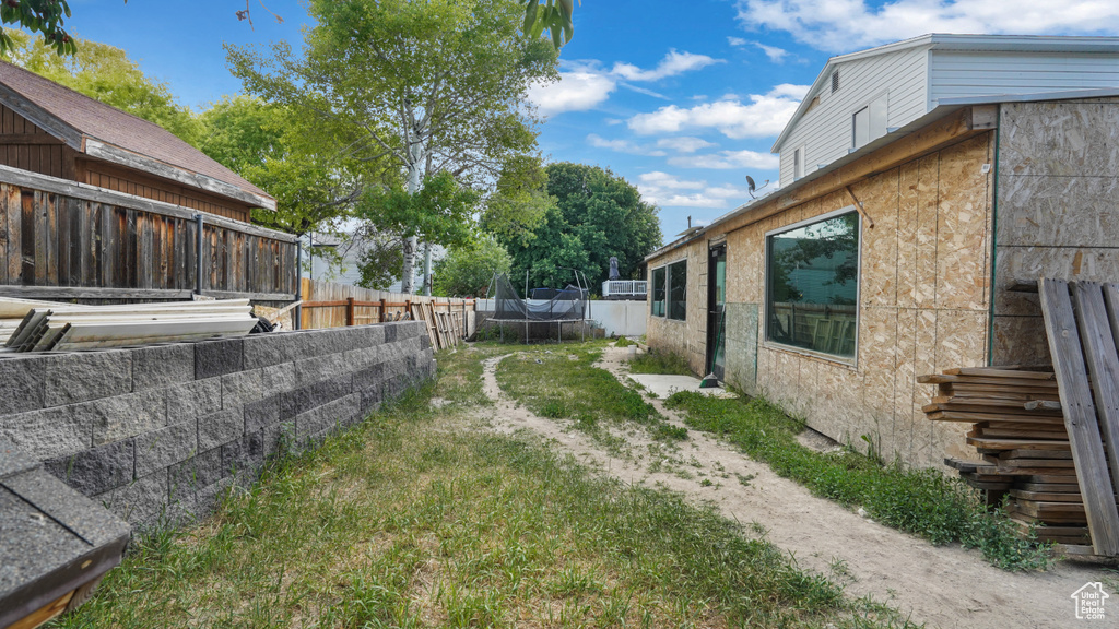 Fenced backyard with a trampoline