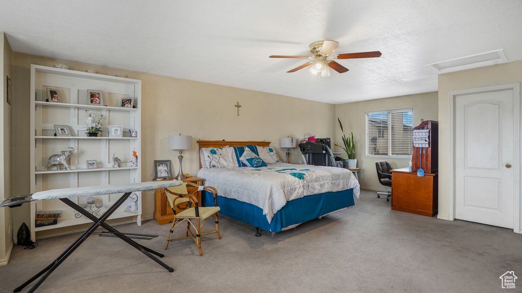 Bedroom featuring carpet floors, attic access, and ceiling fan