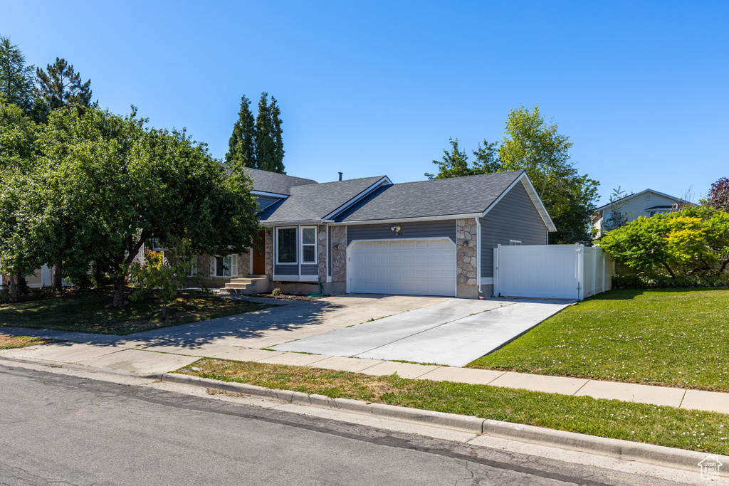 View of front of house featuring a garage, a shingled roof, and concrete driveway
