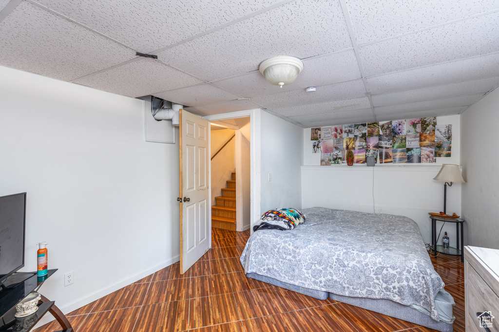 Bedroom featuring a paneled ceiling and baseboards