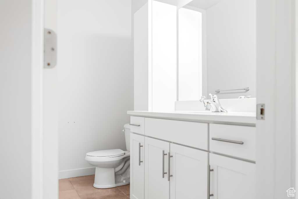 Bathroom with vanity, toilet, and tile patterned floors