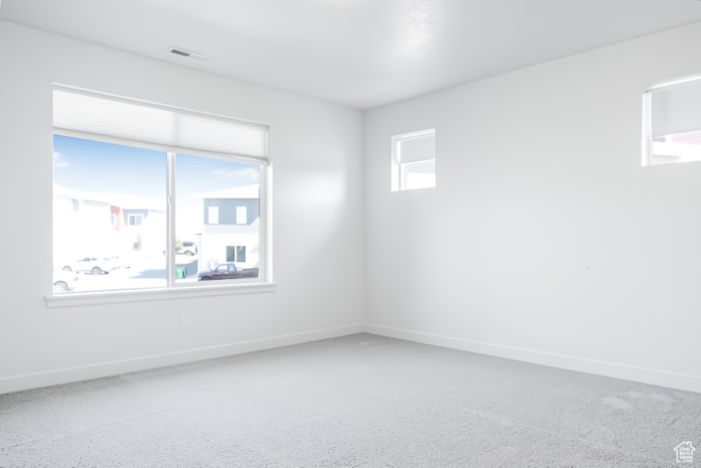 Spare room featuring baseboards and carpet