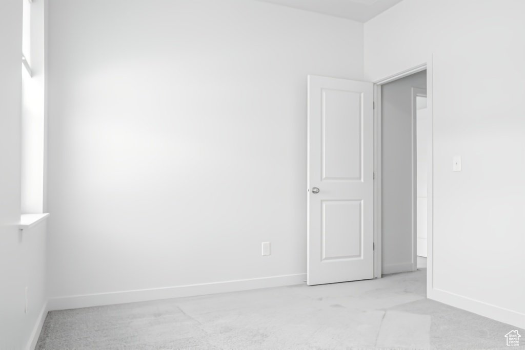 Empty room with light carpet and baseboards