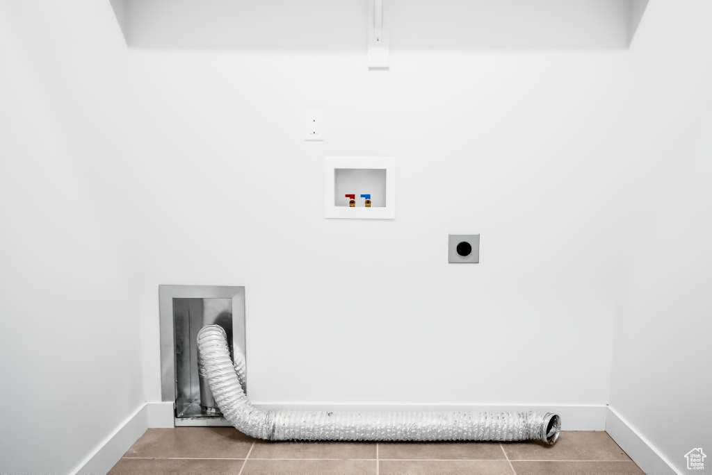 Laundry area featuring hookup for an electric dryer, washer hookup, tile patterned floors, and baseboards