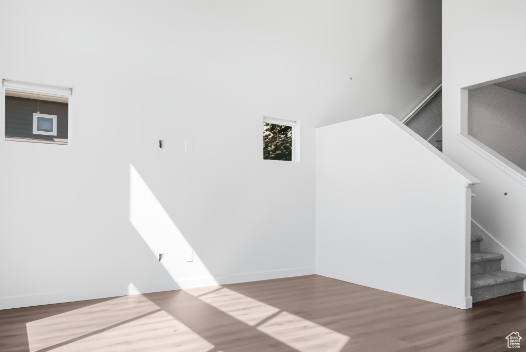 Laundry room with wood finished floors and a towering ceiling