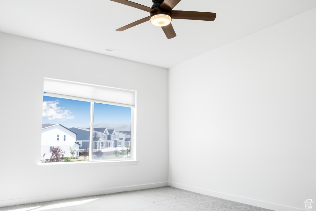 Spare room featuring a ceiling fan and baseboards