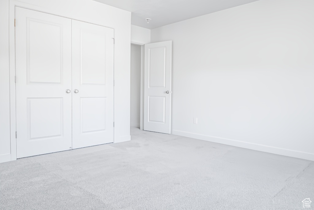 Unfurnished bedroom with carpet flooring, a closet, and baseboards