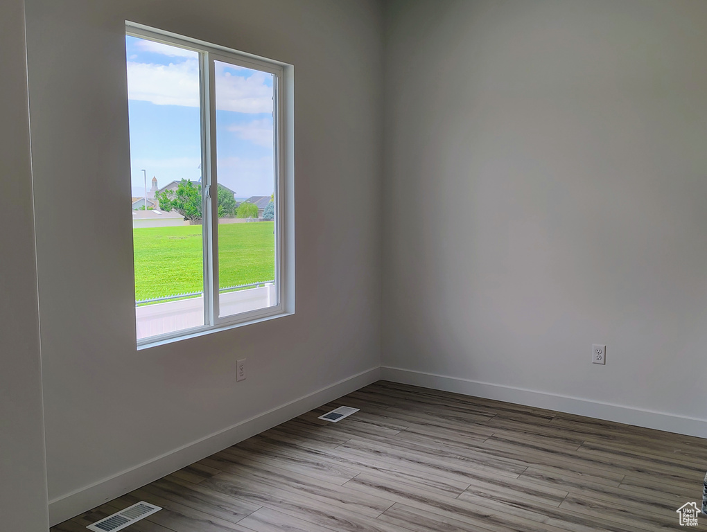 Spare room featuring baseboards and wood finished floors