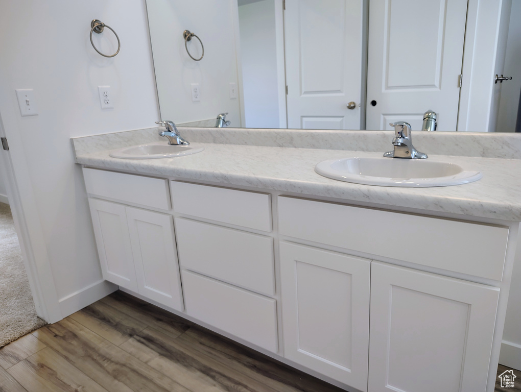 Full bath featuring double vanity and wood finished floors