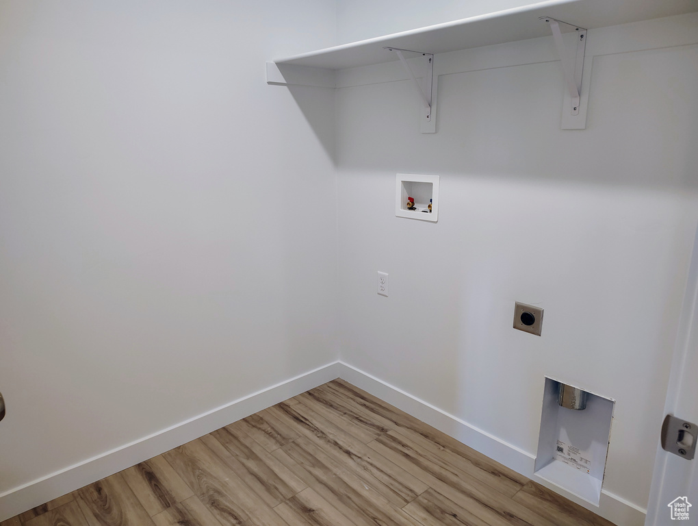 Laundry room with light wood-type flooring, washer hookup, and electric dryer hookup